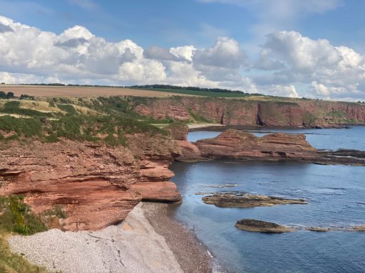 Carlingheugh Bay looking North.  A natural bay with caves, cliffs and stony beaches